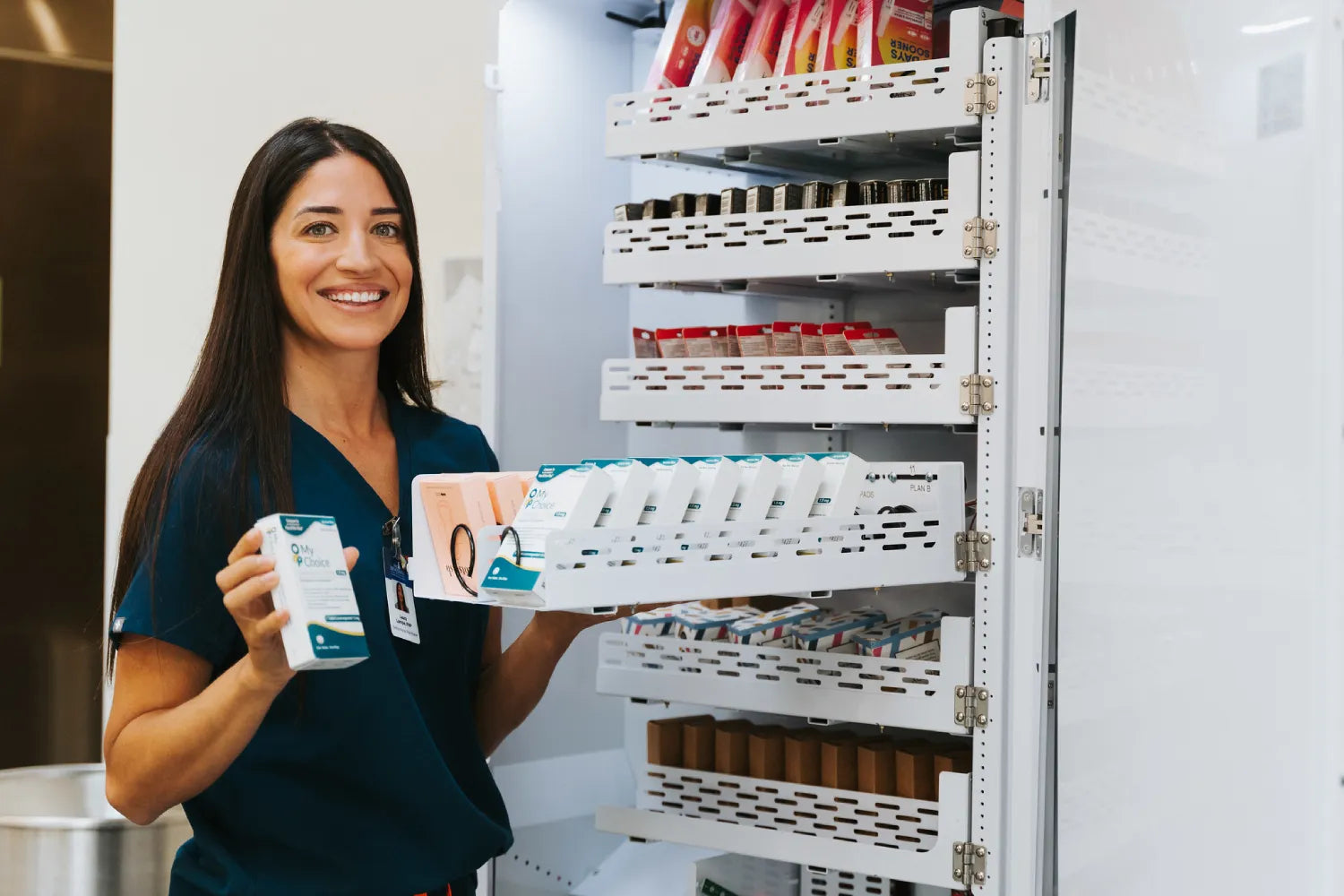 School staff restocking Dotstash Health and Wellness Vending Machine with student care products on campus.